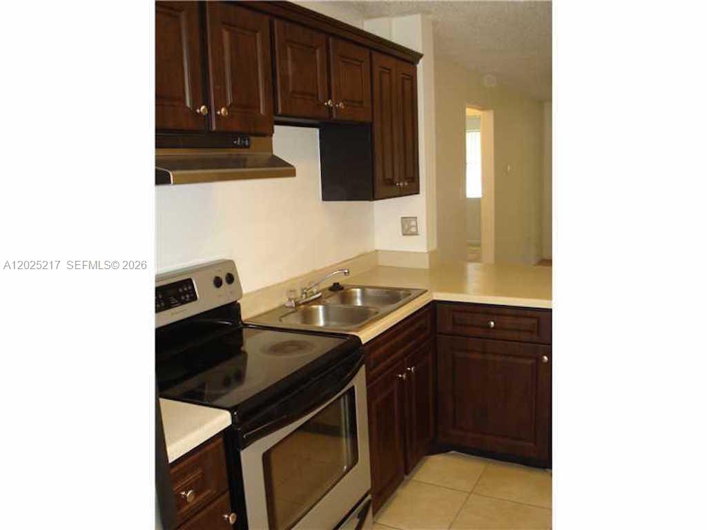 A kitchen features dark wood cabinets, stainless steel appliances, and a double-basin sink — 2240 SW 81st Ave # 2240, Miramar FL 33025, MIRAMAR, FL