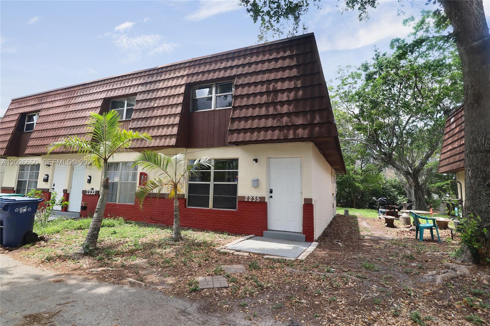 A two-story townhouse exterior features a brown mansard roof and a red brick base — 2235 NW 59th Way # 2235, Lauderhill FL 33313, LAUDERHILL, FL