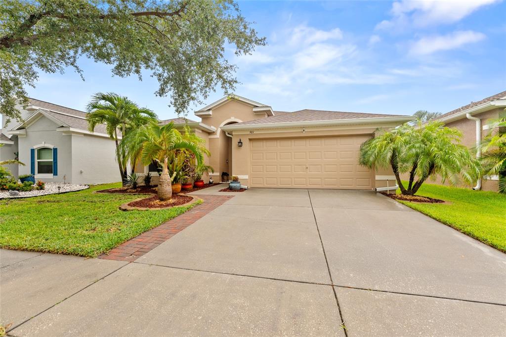 A single-story house with a beige exterior, a two-car garage, and a concrete driveway — 901 PARKER DEN DRIVE, RUSKIN, FL