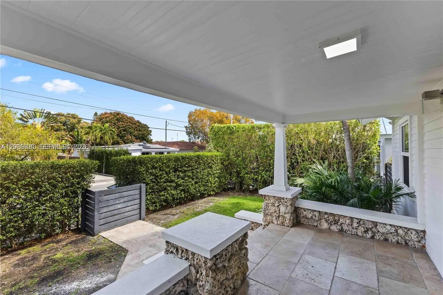 A covered porch features stone pillars, a tiled floor, and a view of the yard — 2434 SW 15th St # 2434, Miami FL 33145, MIAMI, FL