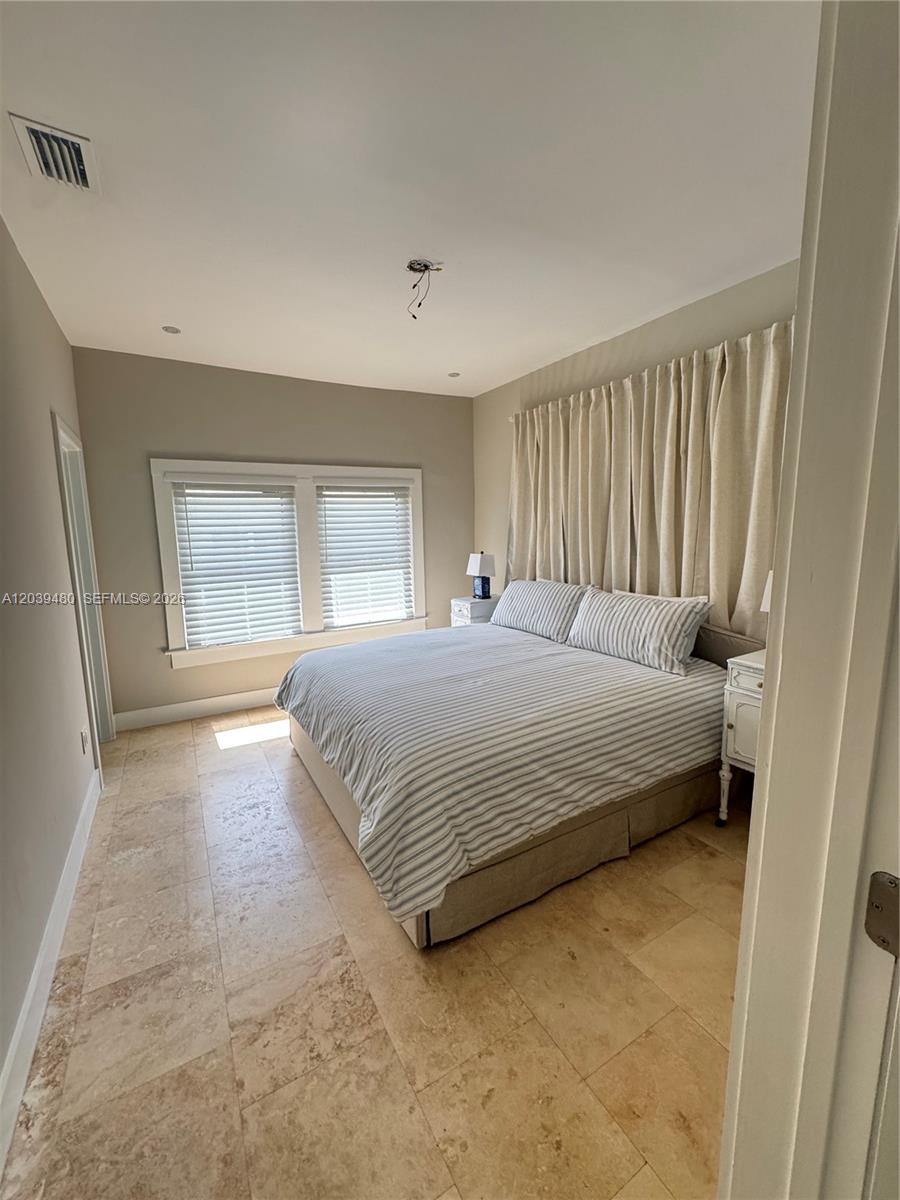 A bedroom features a bed with striped bedding, tile flooring, and floor-to-ceiling curtains — 2434 SW 15th St # 2434, Miami FL 33145, MIAMI, FL