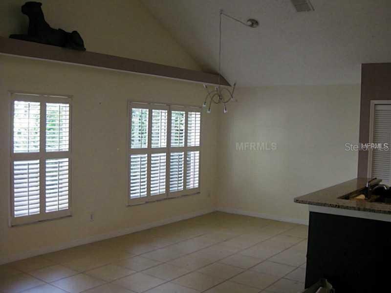 A room with tile flooring, plantation shutters on the windows, and a vaulted ceiling — 4032 BOLINAS COURT, ORLANDO, FL