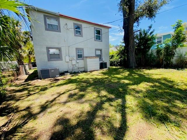 The exterior of a two-story light-colored house features several windows and an outdoor air conditioning unit — 2511 10TH AVENUE S, ST PETERSBURG, FL