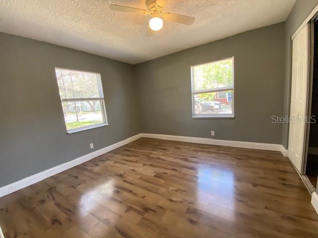 An empty bedroom features gray walls, wood-look flooring, two windows, and a ceiling fan — 2511 10TH AVENUE S, ST PETERSBURG, FL