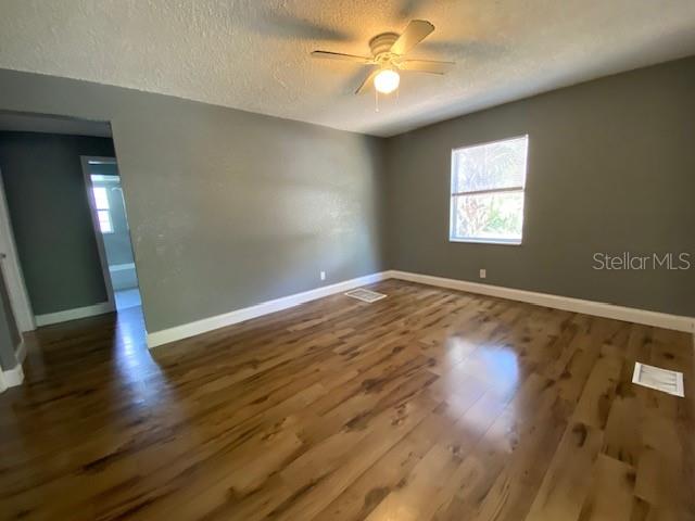 An empty bedroom features gray walls, wood-look flooring, a ceiling fan, and a window — 2511 10TH AVENUE S, ST PETERSBURG, FL