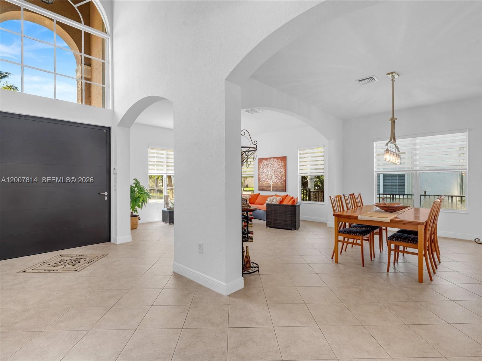 A dining area and living space are connected by arched doorways in this tiled home — 4961 SW 173rd Ave, Miramar FL 33029, MIRAMAR, FL