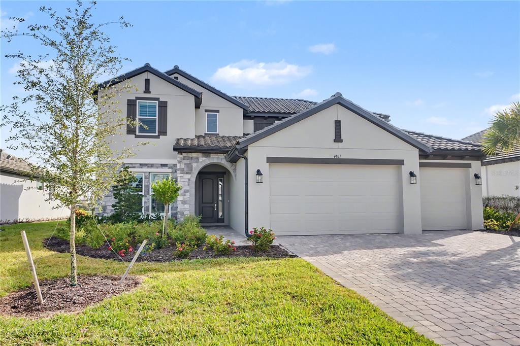 An open-concept living and kitchen area features light wood flooring and a view of water — 4811 HONEY DEW LANE, BRADENTON, FL