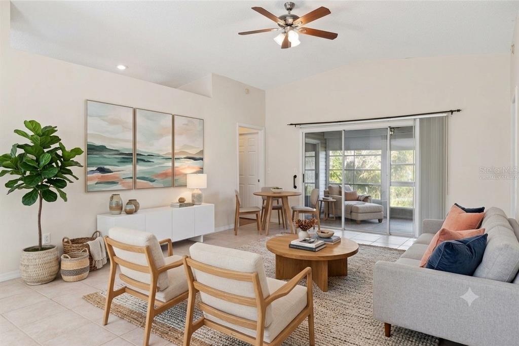 A living room with a sofa, two armchairs, a coffee table, and a dining area — 29327 ZELLER AVENUE, SAN ANTONIO, FL