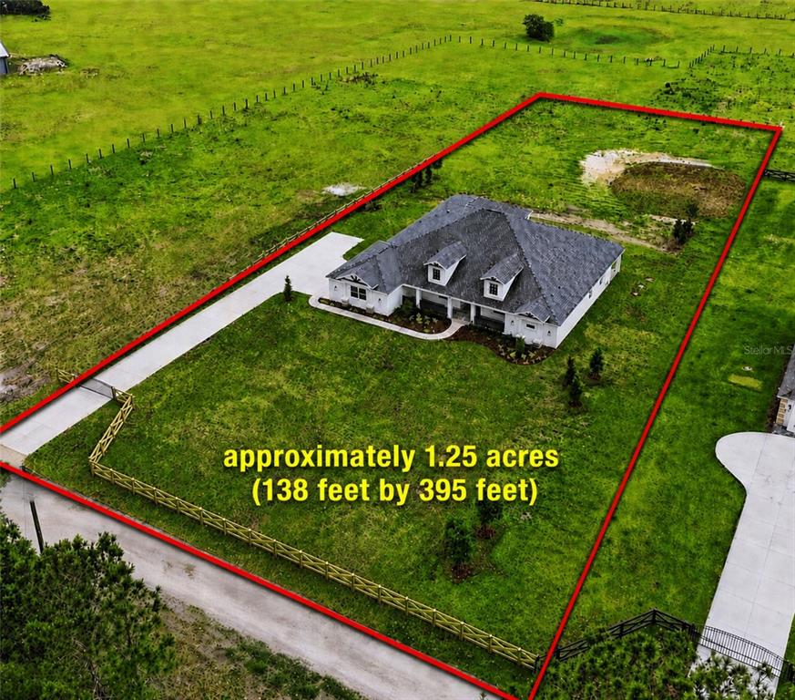 An aerial view shows a house on a rectangular lot outlined in red — 3264 STATION BOULEVARD, BROOKSVILLE, FL