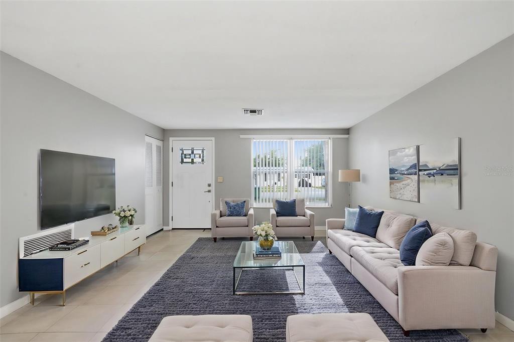 A living room features a grey rug, a white sofa, two armchairs, and a television console — 2281 CONWAY DRIVE, DELTONA, FL