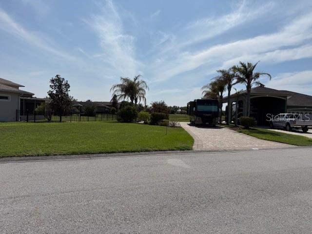 A paved driveway leads to a covered parking structure next to a grassy yard — 368 NOLANE LANE, POLK CITY, FL