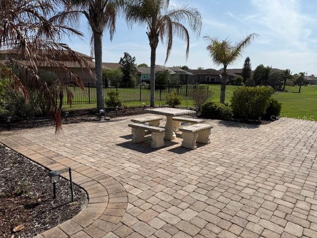 A stone patio features a stone table and bench set surrounded by palm trees — 368 NOLANE LANE, POLK CITY, FL