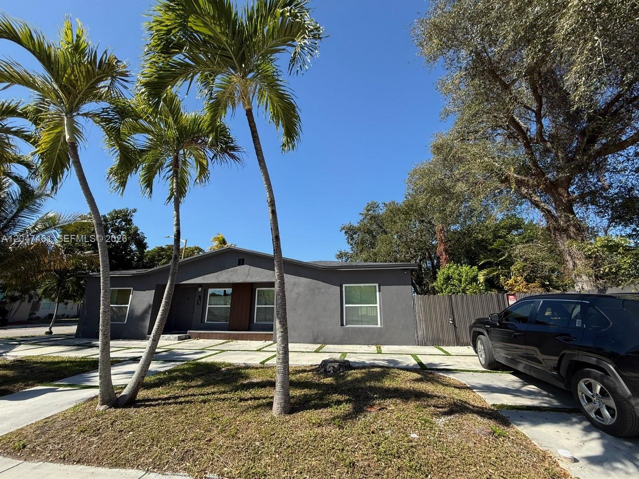 A single-story gray house with a paved driveway and palm trees in the front yard — 6700 NW 5th Ave, Miami FL 33150, MIAMI, FL
