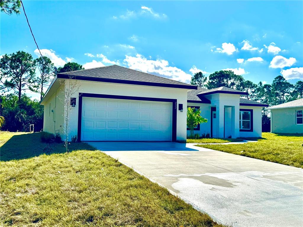 A single-story house with a white exterior, dark trim, and a two-car garage — 222 TITAN ROAD SE, PALM BAY, FL