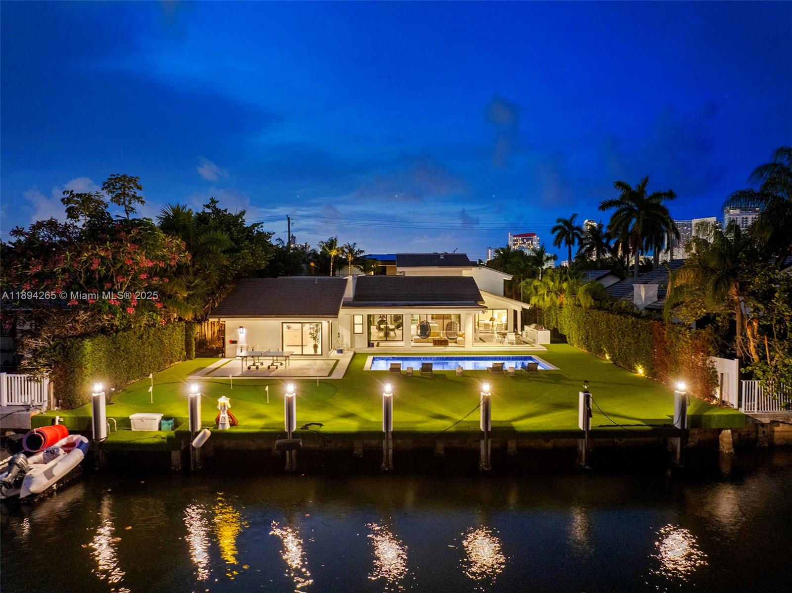 An aerial view of a waterfront house with a pool, putting green, and boat dock — 207 Holiday Dr, Hallandale Beach FL 33009, HALLANDALE BEACH, FL