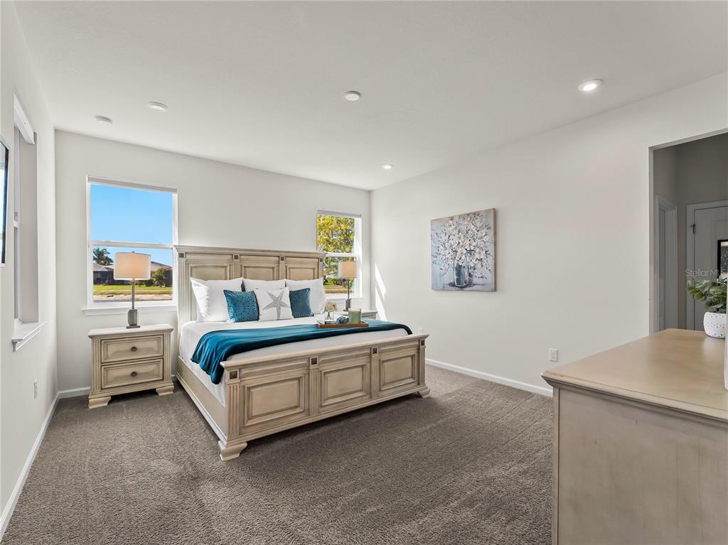 An open-concept kitchen and dining area features wood-look flooring, white cabinetry, and granite countertops — 20381 MINUET PLACE, VENICE, FL