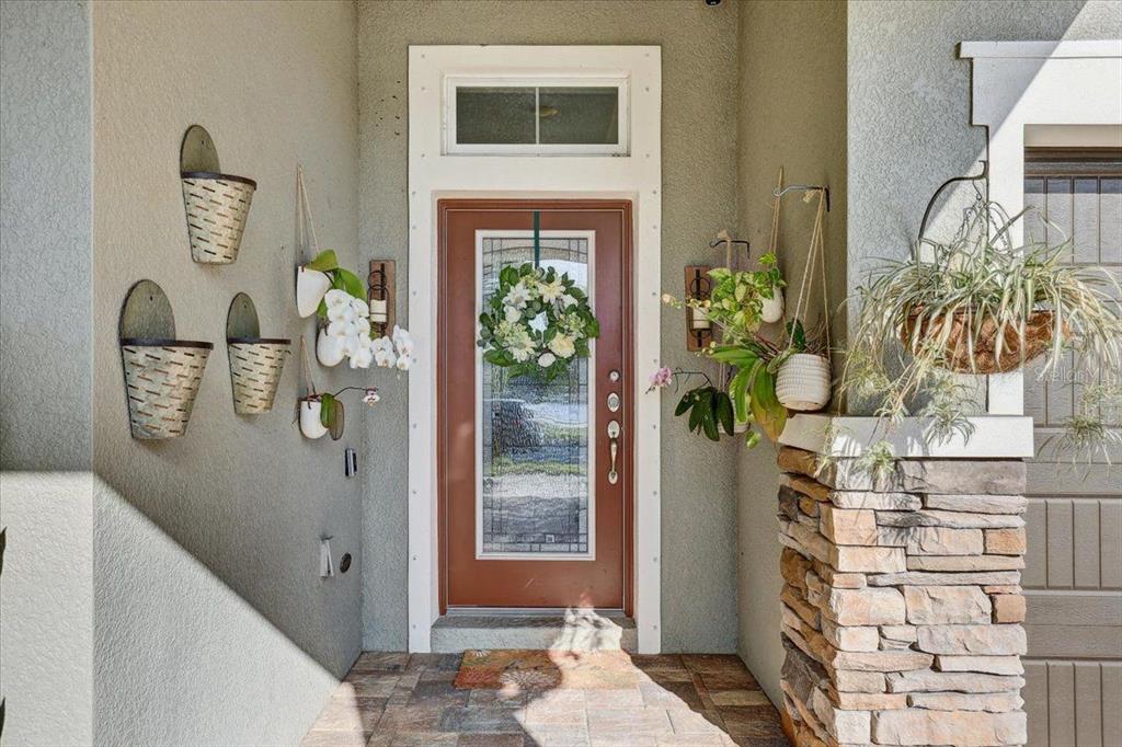 A front entryway features a brown door with a glass insert, a wreath, and wall planters — 7209 MEETING HOUSE LANE, APOLLO BEACH, FL