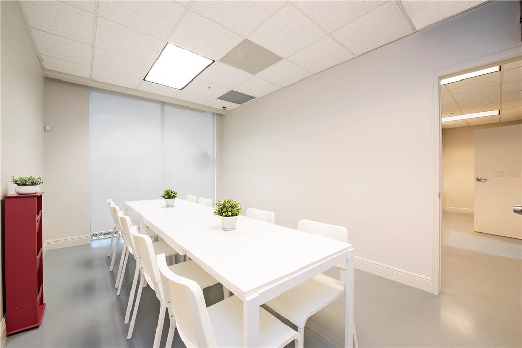 A conference room features a long white table, matching chairs, and a red storage unit — 6557 HAZELTINE NATIONAL DRIVE UNIT C, ORLANDO, FL
