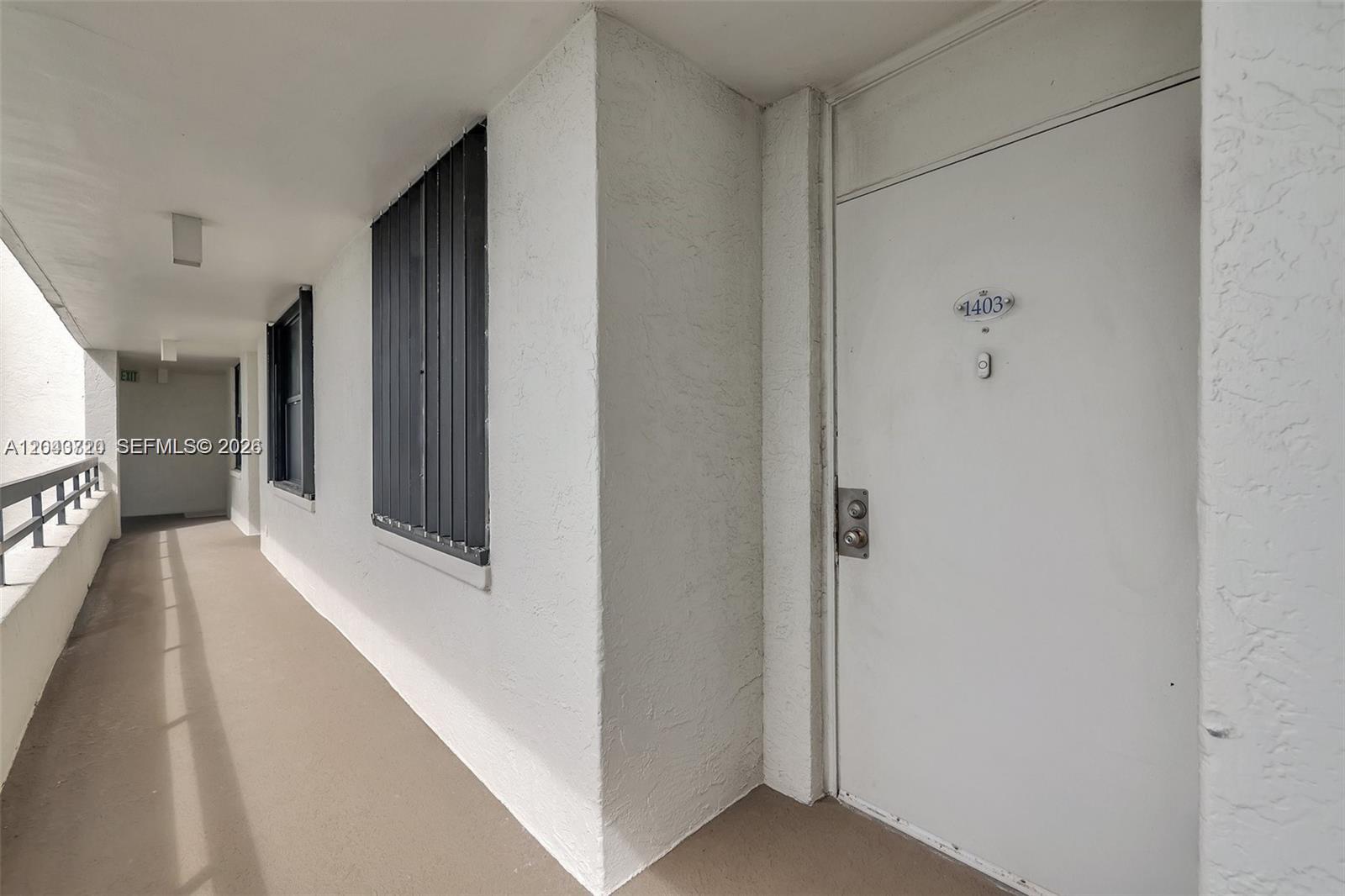 A white apartment door with number 1403 is located along an outdoor concrete hallway — 9650 S Ocean Dr # 1403, Jensen Beach FL 34957, JENSEN BEACH, FL