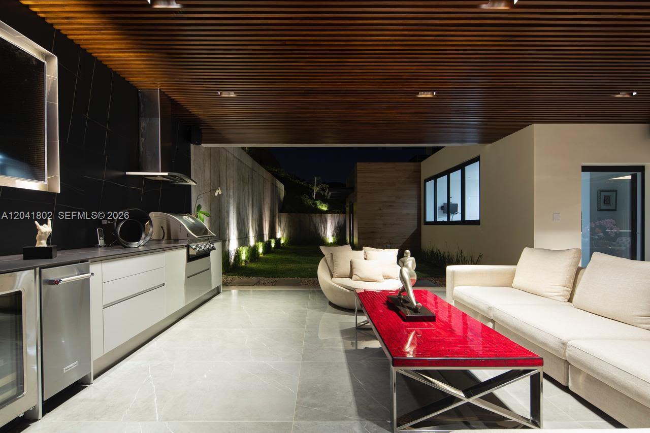 An outdoor kitchen and living area features a slatted wood ceiling and stone flooring — 37-3 ESCAZU, CR 1556-M-000, CR
