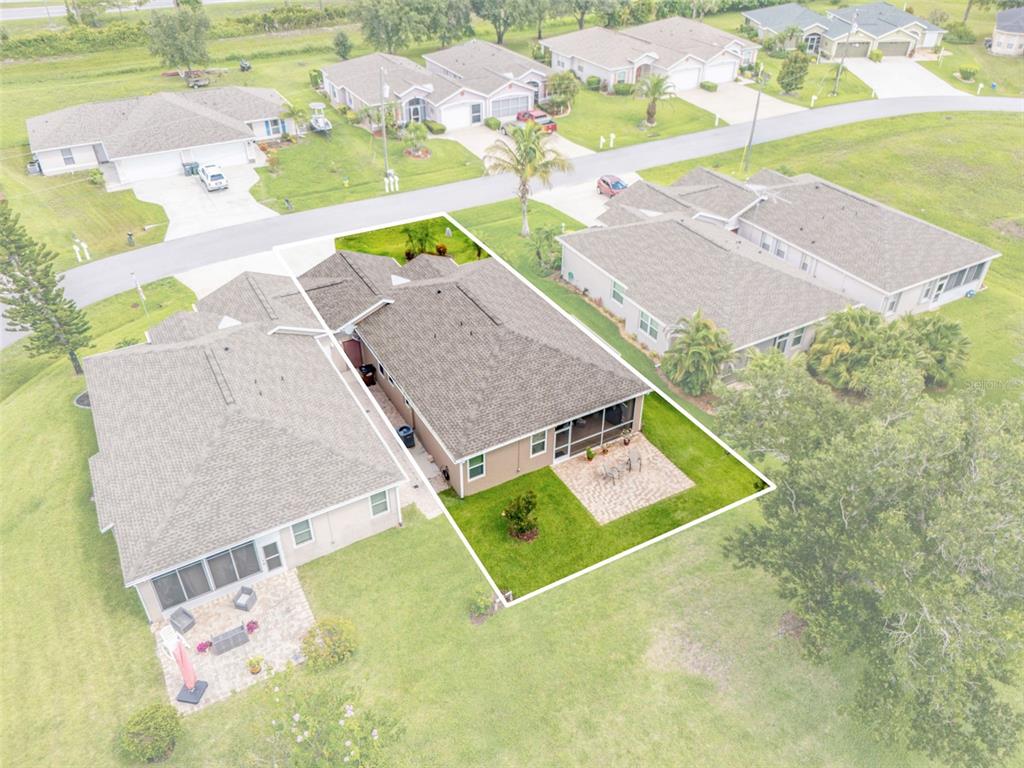 An aerial view shows a single-story house with a backyard patio and lawn — 1351 HEDGEWOOD CIRCLE, NORTH PORT, FL