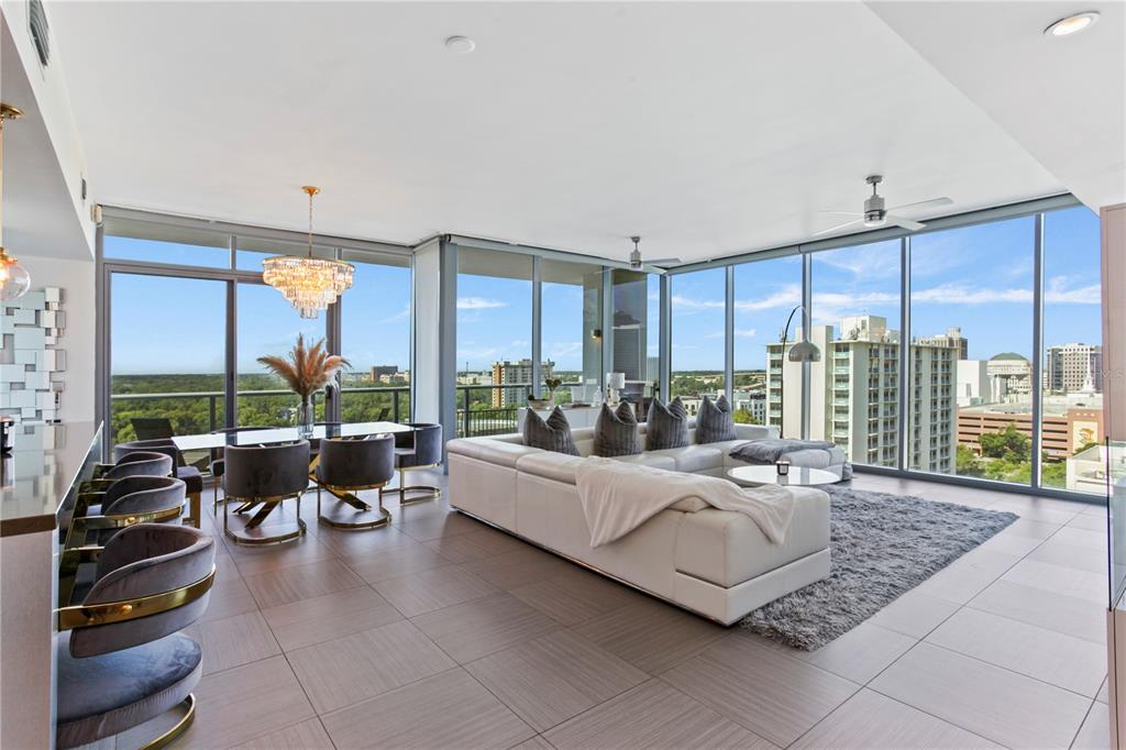 A modern, open-concept living and dining area features floor-to-ceiling windows with city views — 260 S OSCEOLA AVENUE UNIT 1106, ORLANDO, FL