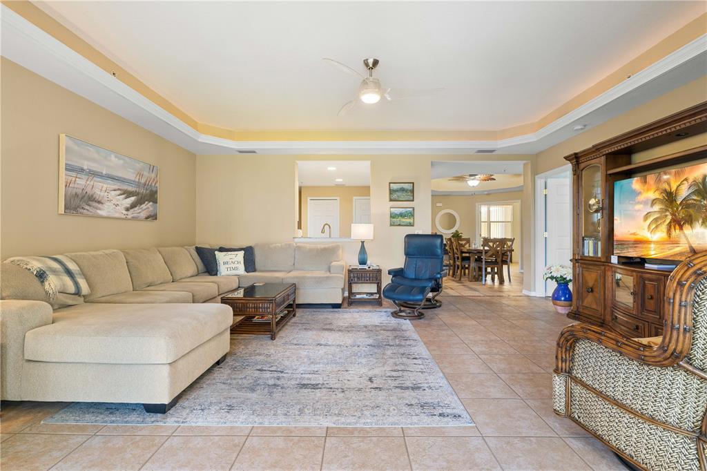 A living room features a beige sectional sofa, a blue recliner, and tile flooring — 255 WEST END DRIVE UNIT 4205, PUNTA GORDA, FL