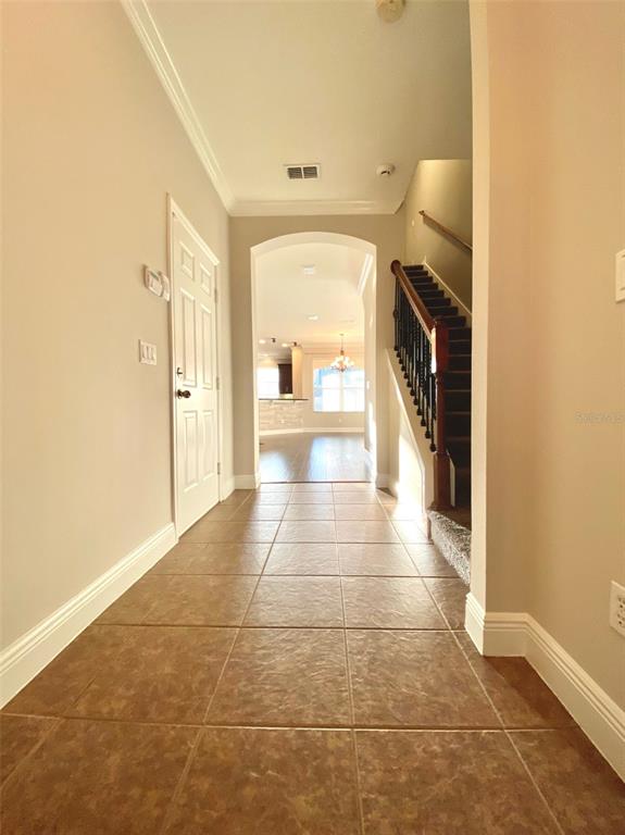 A tiled entryway leads to a staircase and an arched doorway opening into a living area — 4956 LUGE LANE, ORLANDO, FL