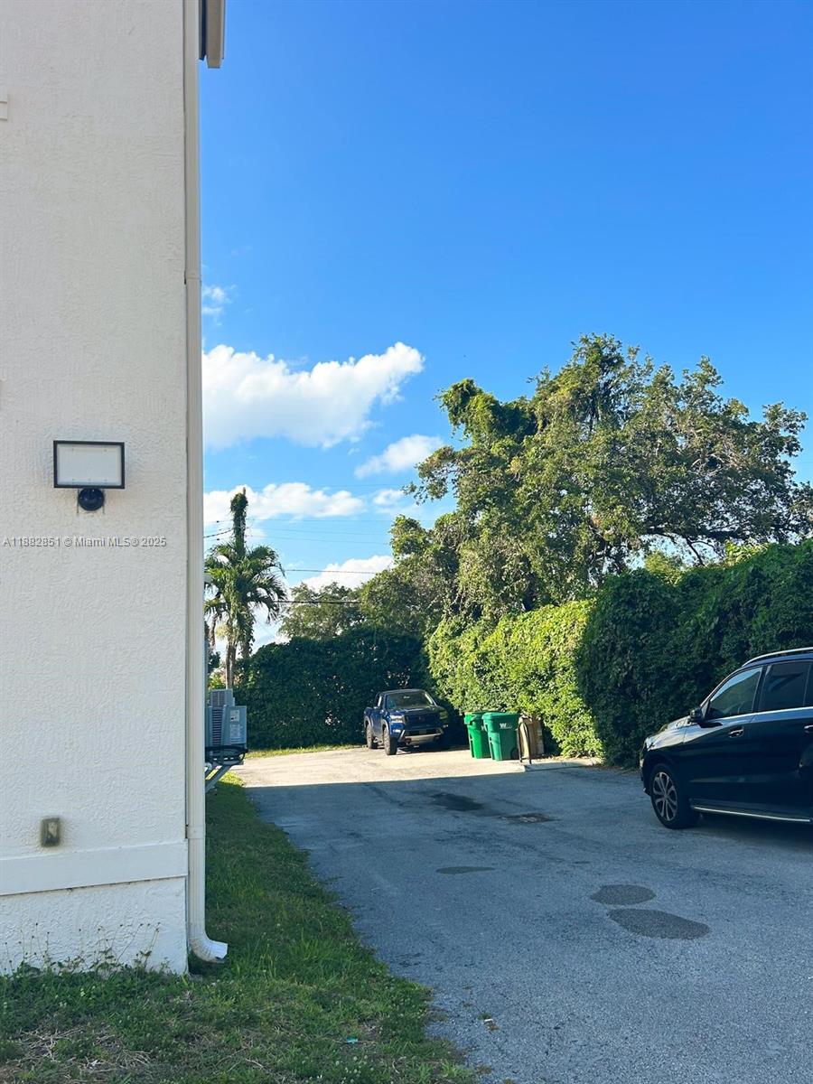 A paved driveway leads to a parking area with two green bins and a truck — 29 Oviedo Ave, Coral Gables FL 33134, CORAL GABLES, FL
