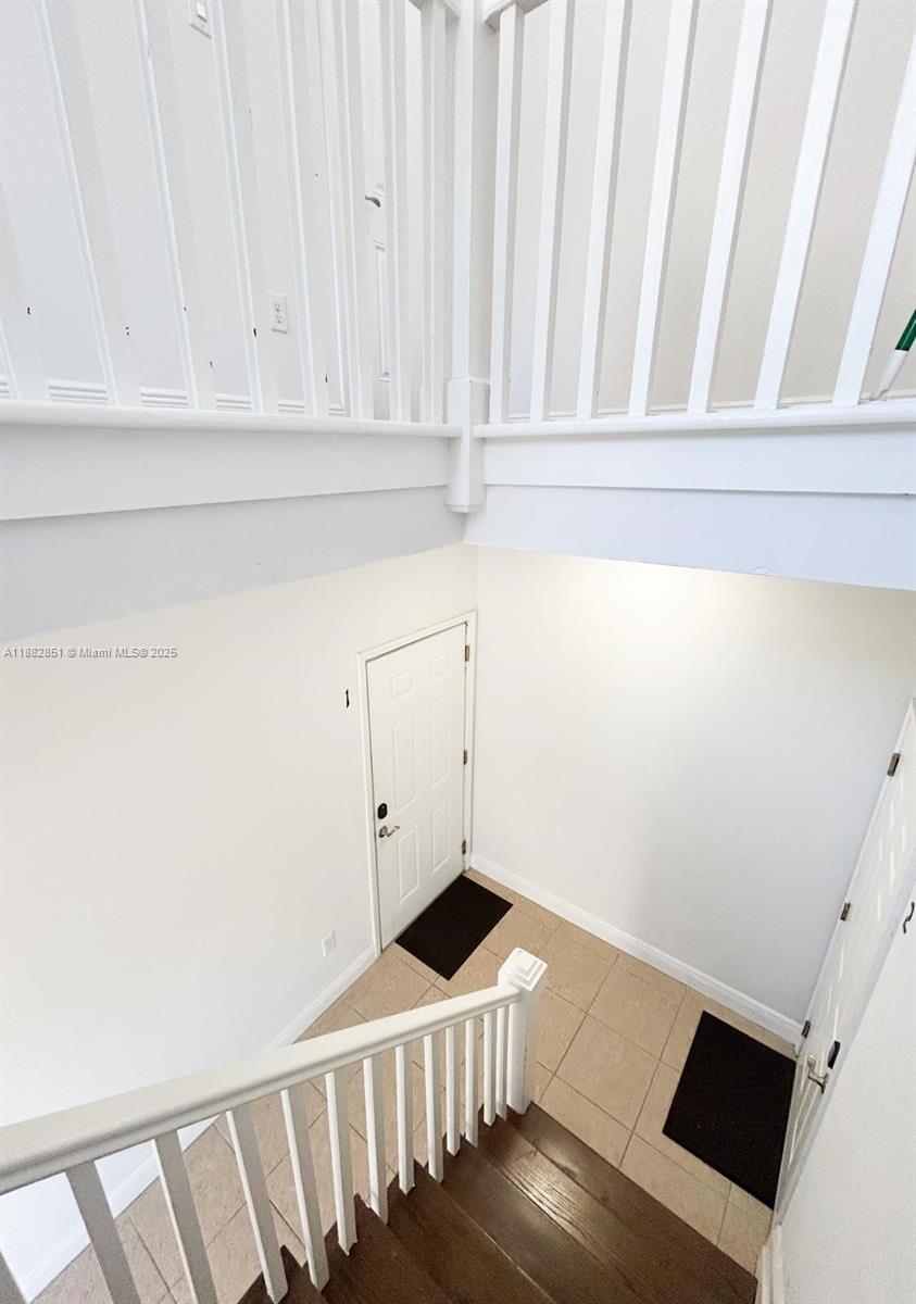 A high-angle view shows a staircase leading down to a tiled entryway with two doors — 29 Oviedo Ave, Coral Gables FL 33134, CORAL GABLES, FL