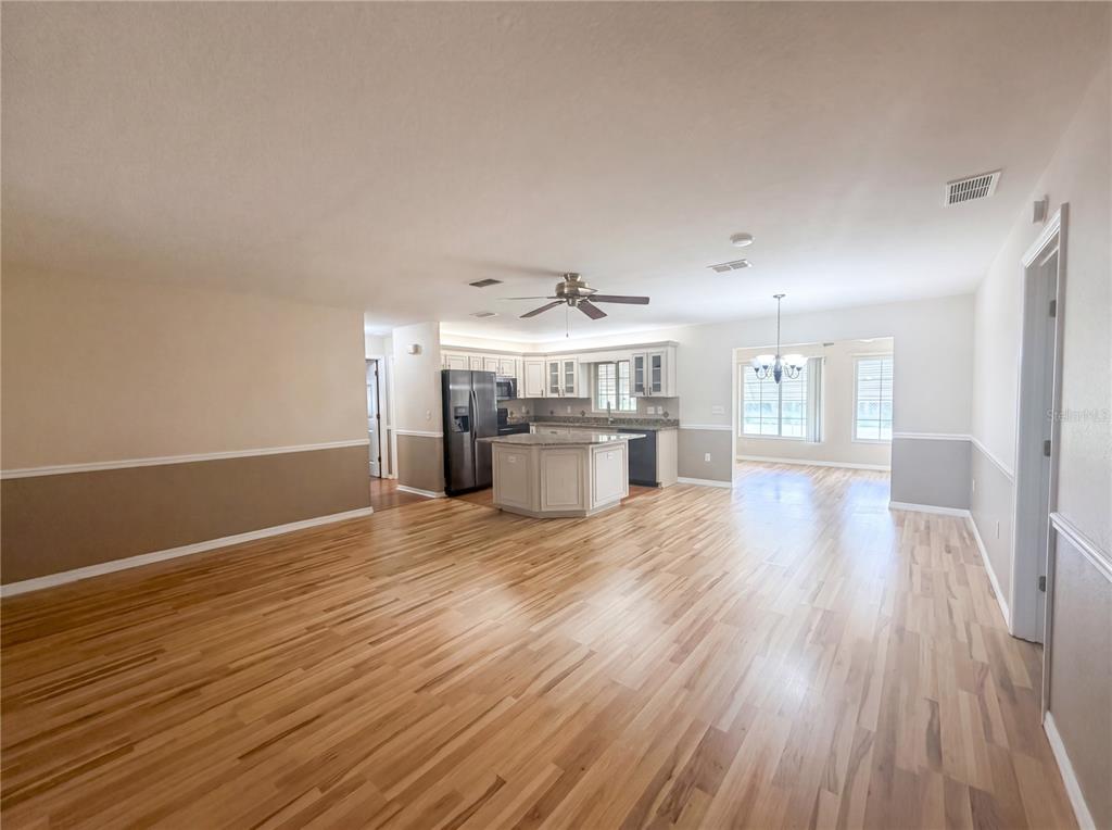 A spacious open-concept living area features hardwood floors, a kitchen island, and a dining nook — 13763 SW 112TH TERRACE, DUNNELLON, FL