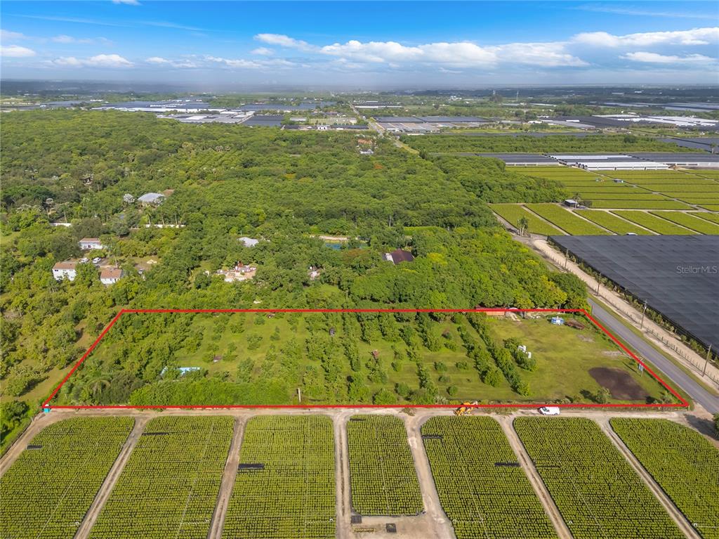 An aerial view shows a rectangular plot of land outlined in red near agricultural fields — 15300 SW 216TH, MIAMI, FL