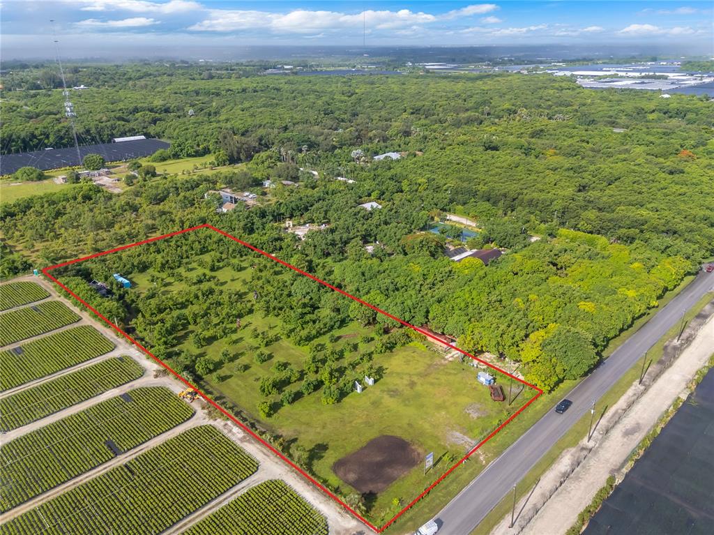 An aerial view shows a rectangular plot of land outlined in red near a road — 15300 SW 216TH, MIAMI, FL