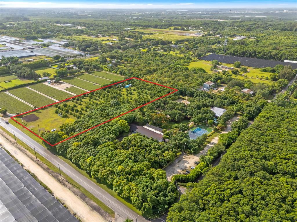 An aerial view shows a rectangular plot of land outlined in red near a road — 15300 SW 216TH, MIAMI, FL