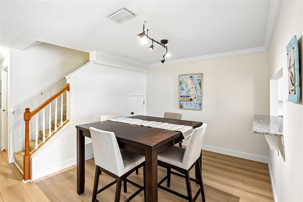 A dining area features a dark wood table, upholstered chairs, and a Florida wall map — 3853 ISLAND WAY, ST PETERSBURG, FL
