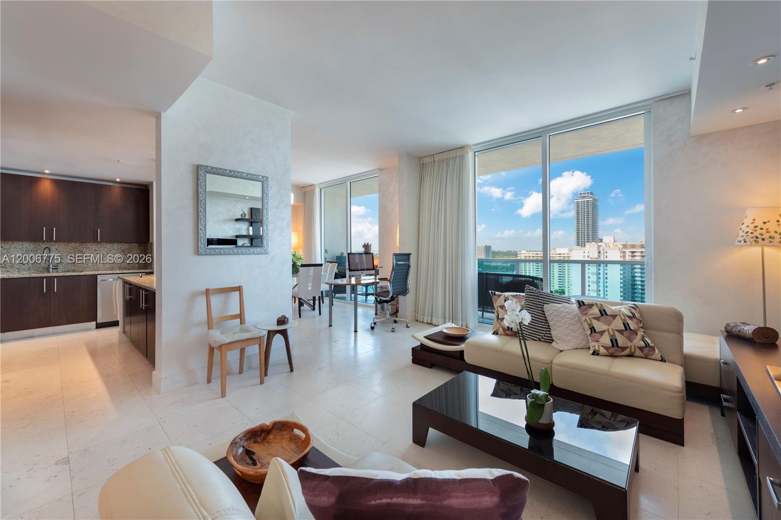 A modern living room features light tile floors, a kitchen, and floor-to-ceiling windows with views — 1945 S Ocean Dr # 1812, Hallandale Beach FL 33009, HALLANDALE BEACH, FL
