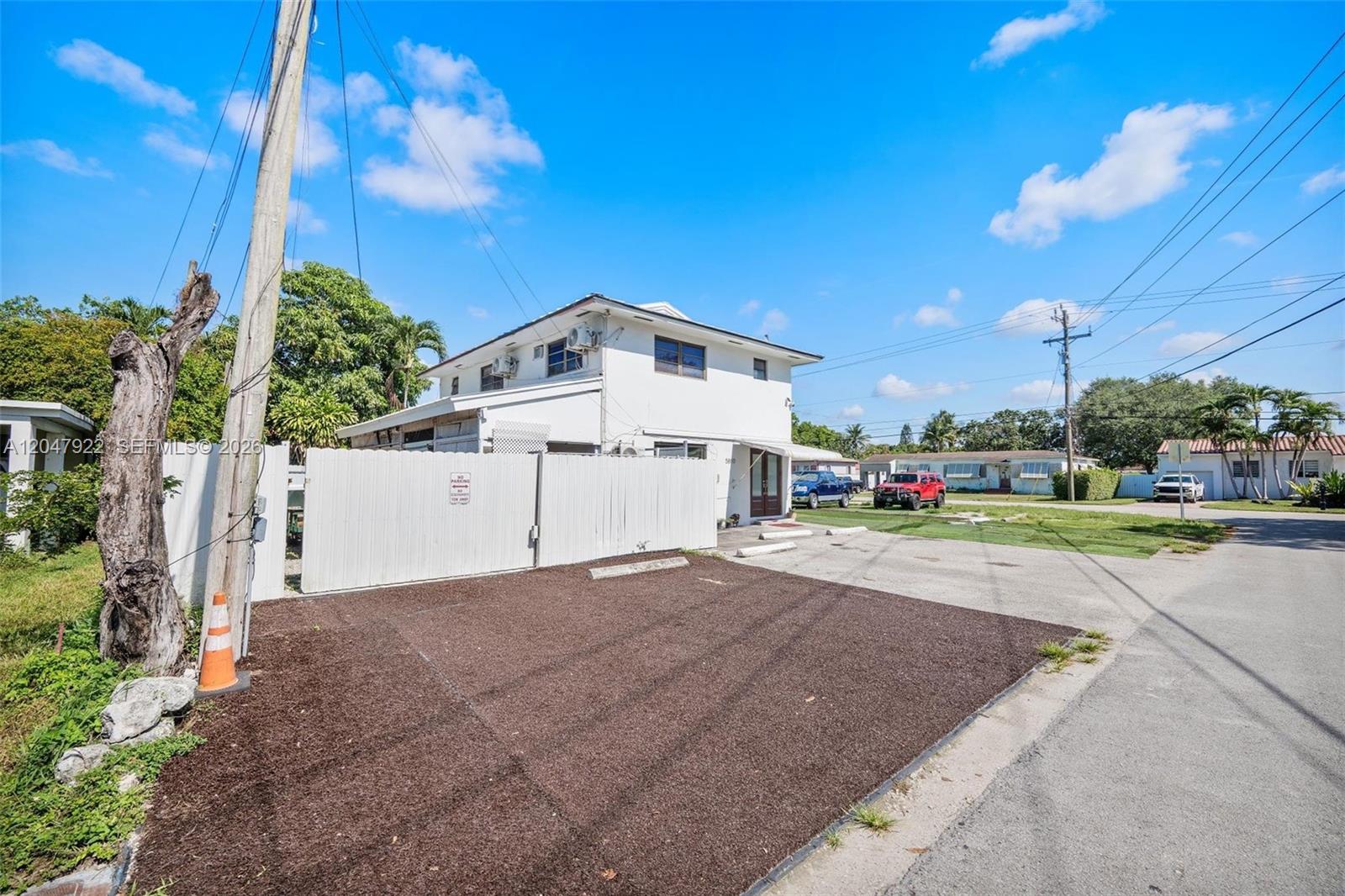 A two-story white building with a fenced parking area and a gravel lot — 5800 SW 20th St, Miami FL 33155, MIAMI, FL