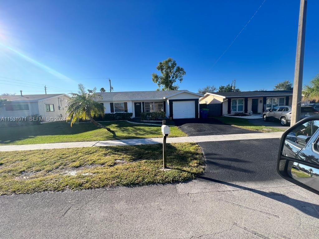 A single-story suburban house with a white exterior, a garage, and a front lawn — 11520 NW 31st Pl, Sunrise FL 33323, SUNRISE, FL