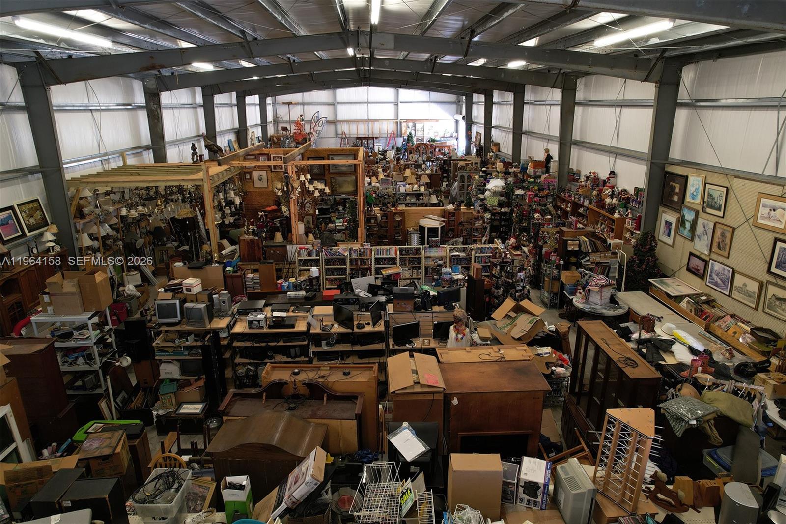 An interior view of a large warehouse filled with various furniture, electronics, and household items — 5271 US HWY 441 SE, Okeechobee FL 34974, OKEECHOBEE, FL