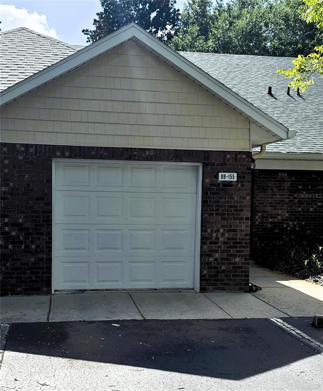 A single-car garage with a white door and brick siding under a shingled roof — 13200 W NEWBERRY ROAD UNIT BB155, NEWBERRY, FL