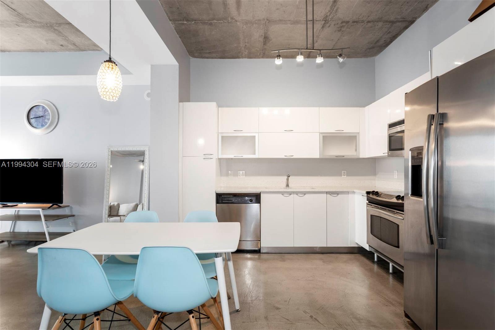 A modern kitchen features white cabinets, stainless steel appliances, and a concrete ceiling — 234 NE 3rd St # 1106, Miami FL 33132, MIAMI, FL