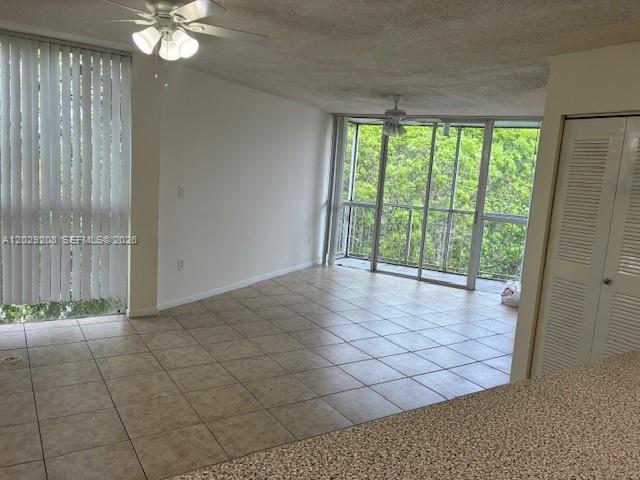 An open living area features tile flooring, a ceiling fan, and large sliding glass doors — 7075 NW 186th St # C507, Hialeah FL 33015, HIALEAH, FL