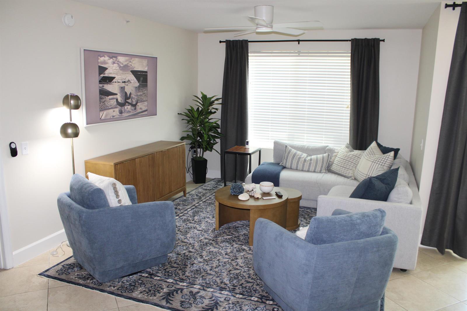 A living room features a light gray sectional, two blue armchairs, and a patterned rug — BOYNTON BEACH, FL