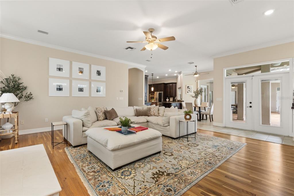 A living room features a white sectional sofa, a large ottoman, and a patterned area rug — 15900 ACORN CIRCLE, TAVARES, FL