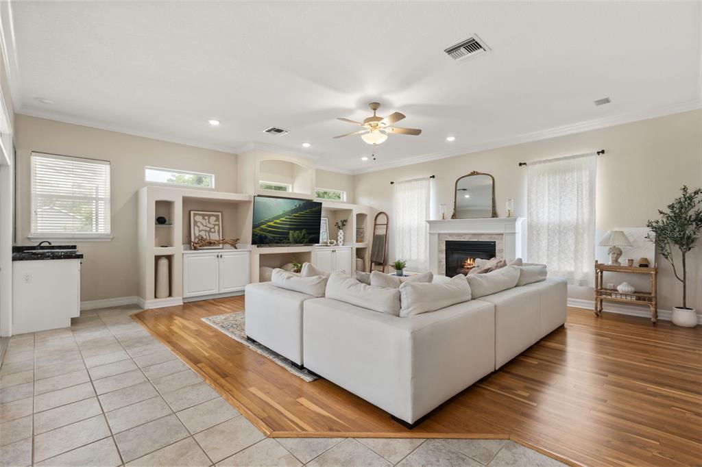 A living room features a large white sectional sofa, a fireplace, and built-in shelving — 15900 ACORN CIRCLE, TAVARES, FL