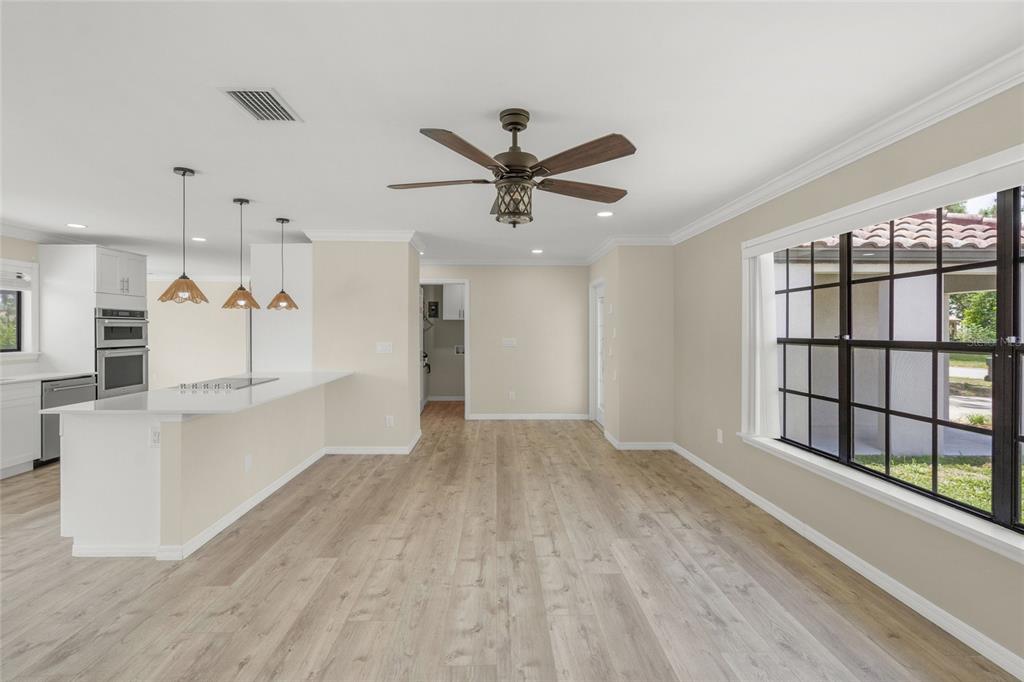 A kitchen with white cabinets, a breakfast bar, and light wood flooring — 5050 RICHMOND TERRACE, NORTH PORT, FL