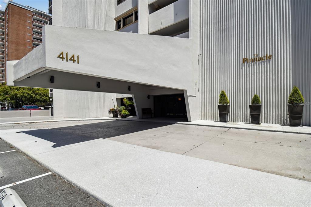 The exterior of a white building features a large covered entryway with the number 4141 — 4141 BAYSHORE BOULEVARD UNIT 1106, TAMPA, FL