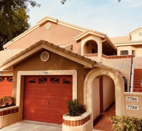 An elevated view shows a tiled roof overlooking a residential street with houses and trees — 7786 SUGAR BEND DRIVE UNIT 7786, ORLANDO, FL