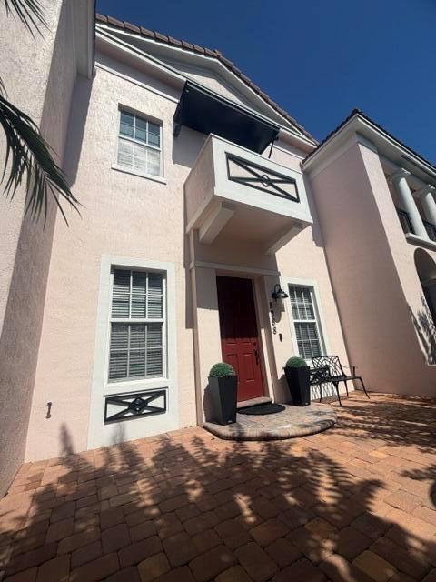 A light-colored stucco house exterior features a red front door, a small balcony, and pavers — 8288 NW 9th Avenue, Boca Raton FL 33487, BOCA RATON, FL