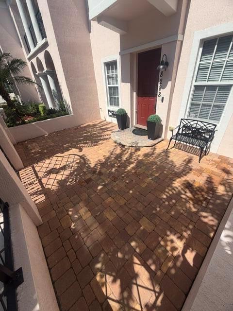 A brick-paved entryway features a red front door, a black metal bench, and potted plants — 8288 NW 9th Avenue, Boca Raton FL 33487, BOCA RATON, FL